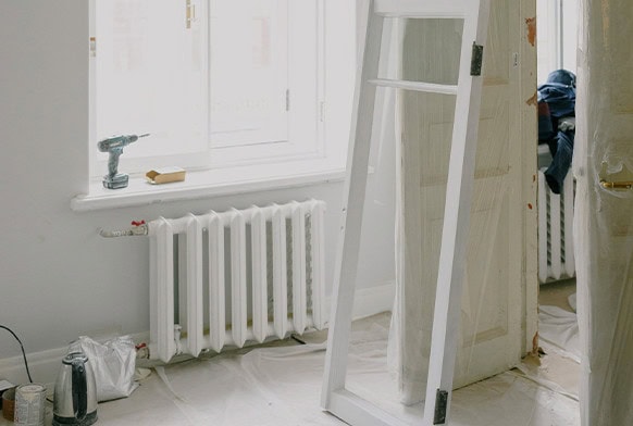 Espace de stockage avec fenêtre, radiateur et porte en cours de montage.